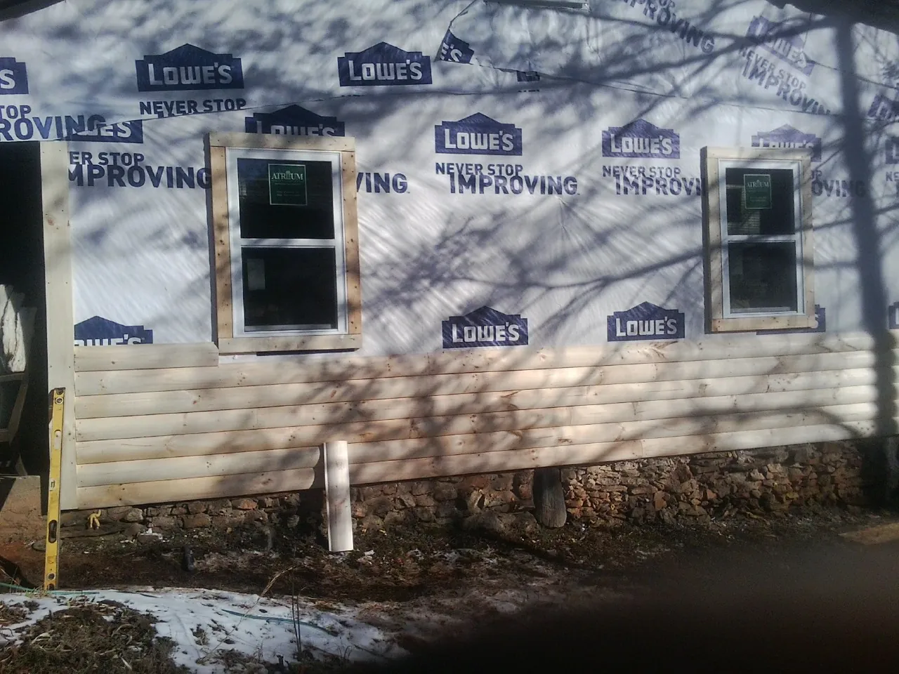 House wrap and new log siding going up on an exterior wall in Brazoria