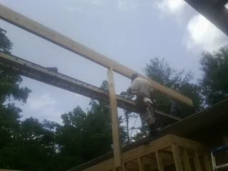 Carpenter setting a ridge beam over a new addition frame — Ice Dam Removal by Roofing Brothers in Brazoria