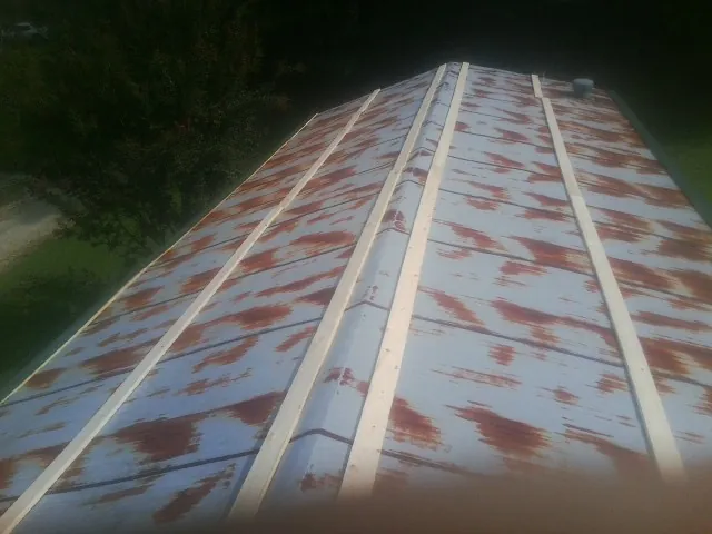 Rusted metal roof panels with new wood purlins before replacement — Storm Damage Roof Repair in Brazoria by Roofing Brothers