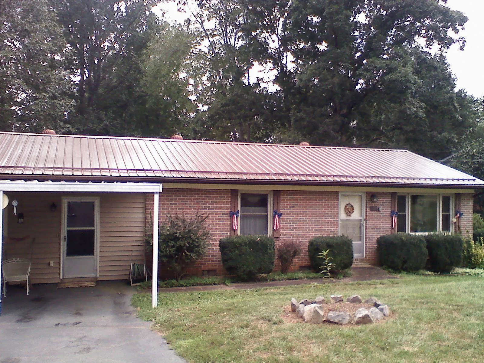 Bronze metal roof and carport on a brick ranch home — Roof Repair work by our crew in Brazoria