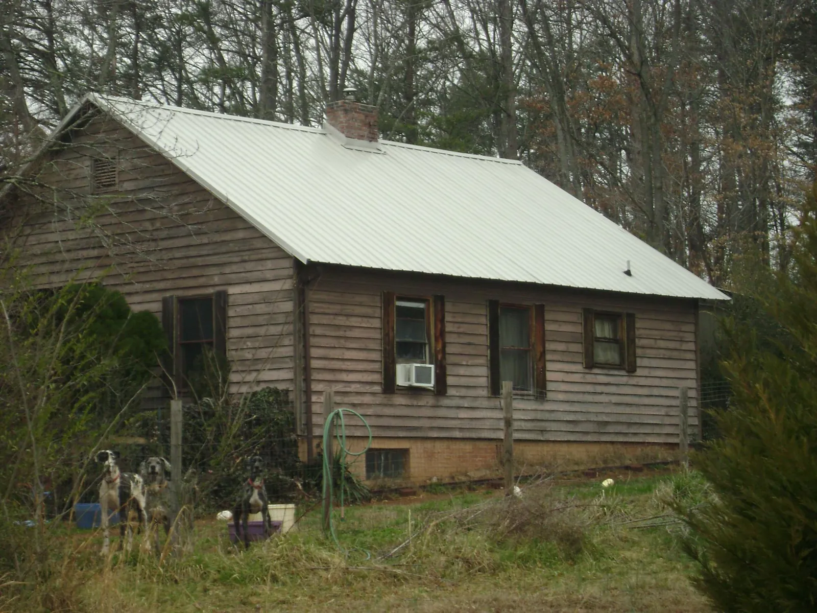 White metal roof on an old wood sided farmhouse, from a Metal Roof Installation job in Brazoria